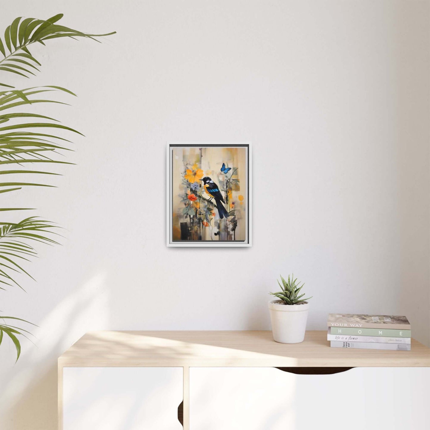Framed colorful bird and butterfly canvas art on a minimalist wall, vibrant home decor accent over a modern console with plant and books.