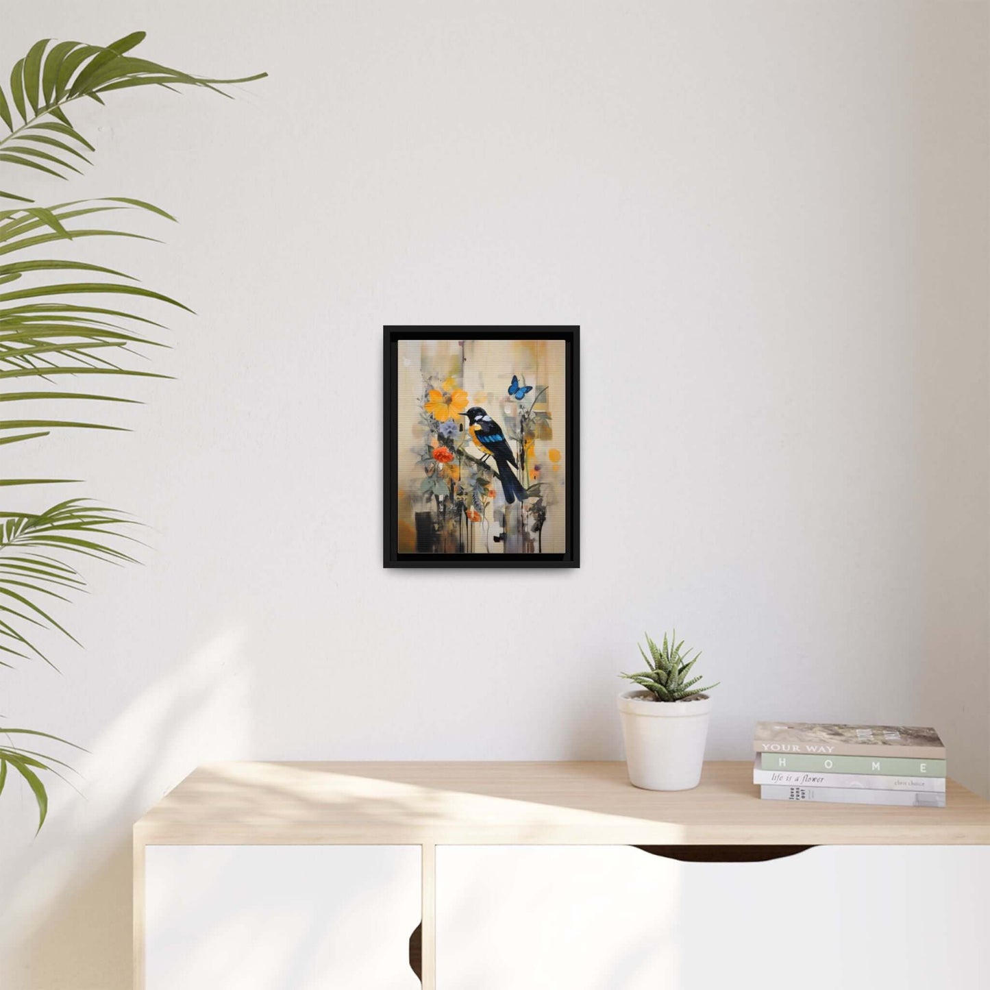 Vibrant framed canvas art featuring a colorful bird and butterfly, perfect for modern home decor; displayed on a white wall above a cabinet.