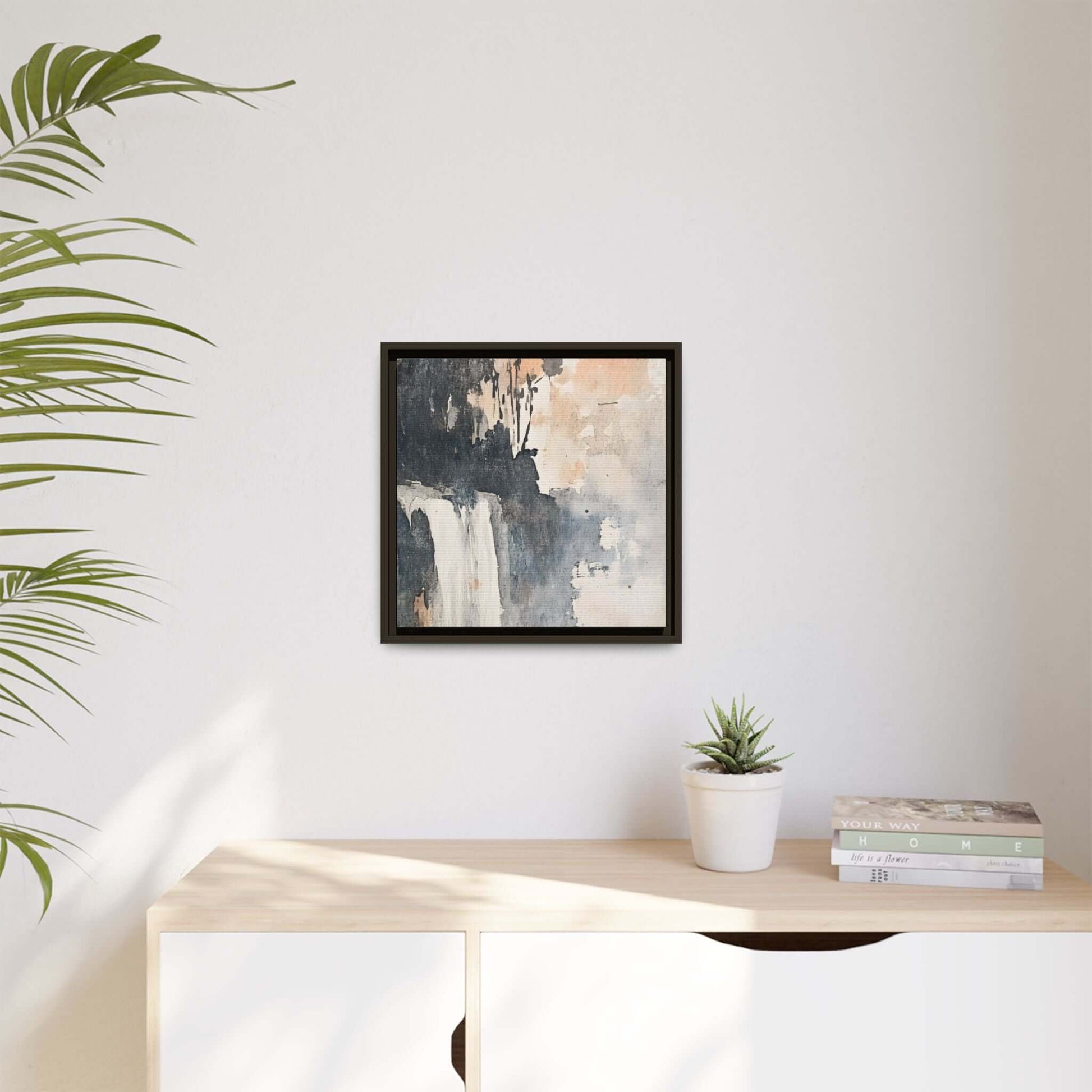 Framed waterfall art print on matte canvas in modern home decor setting, featuring a minimalistic room with plants and books.