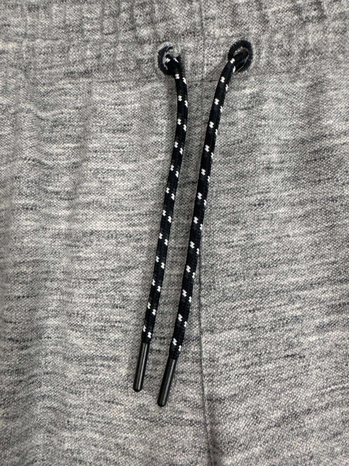 Close-up of grey Adidas jogger pants with black drawstring, showcasing soft fabric and elastic waistband.
